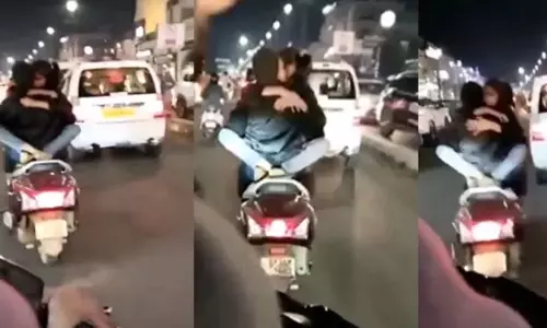 என்னடா நடக்குது இங்க? -டூவீலரில் ரொமான்ஸ் செய்தபடி பயணித்த காதல் ஜோடி - வைரலாகும் வீடியோ